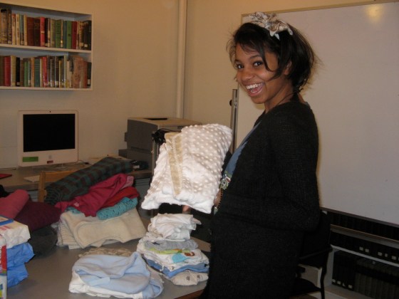 My high school feminism student, Ayana, organizes baby clothes to deliver to the children of GEMS girls in 2009 (photo credit: Ileana Jiménez).